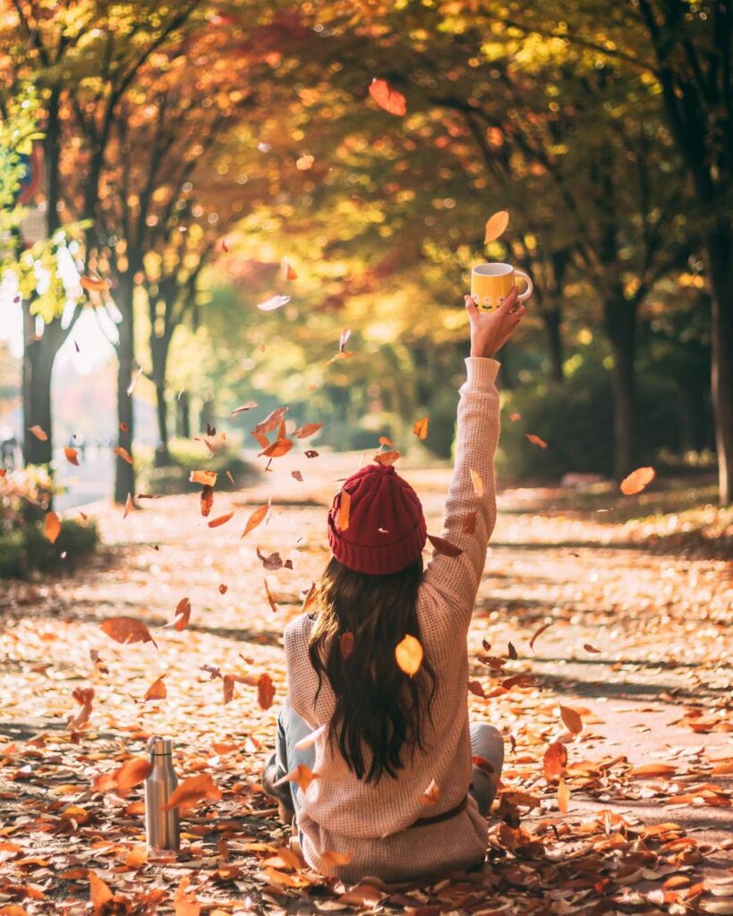 A person enjoying the Fall foliage in New England — best places to travel in October